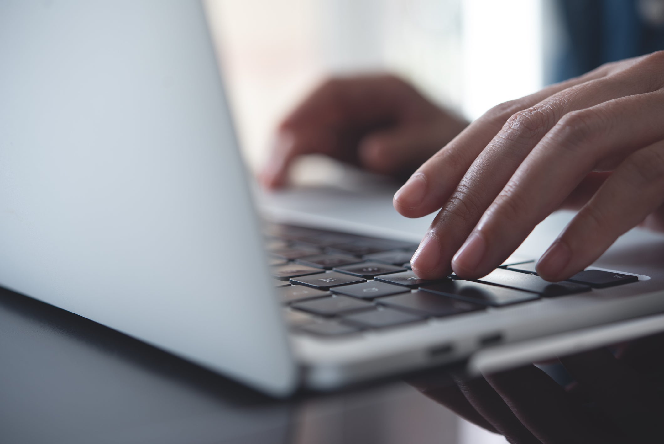 Photo of someone typing on a laptop