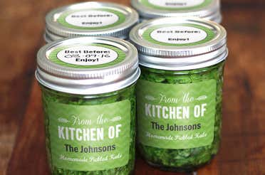  Four glass jars full of kale with the same green label added on all of them.