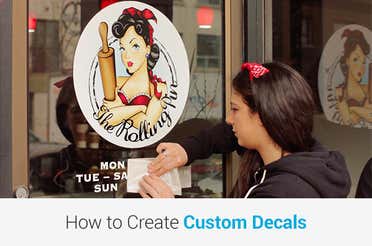 Business owner applying vinyl lettering and a custom decal to a bakery window