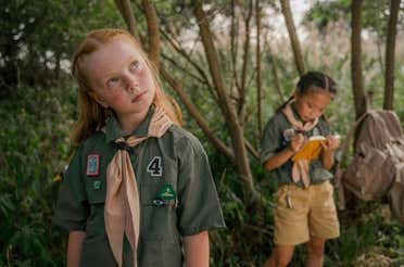 Two girls wearing uniforms with patches.