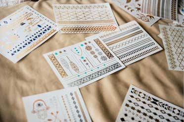 Many temporary tattoos are placed on a sheet.