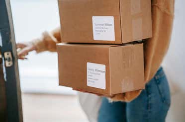 A woman carrying packages with address labels