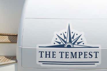 A white boat with a vinyl decal of its name.