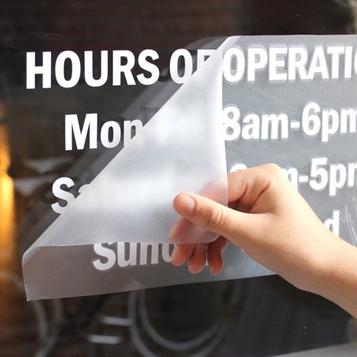 Vinyl lettering and number store hours on a window