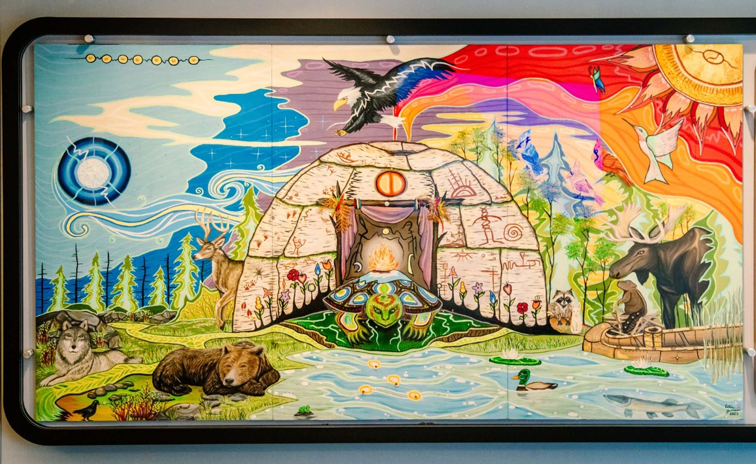 A large wall painting depicting a bear surrounded by various other animals in a natural setting.