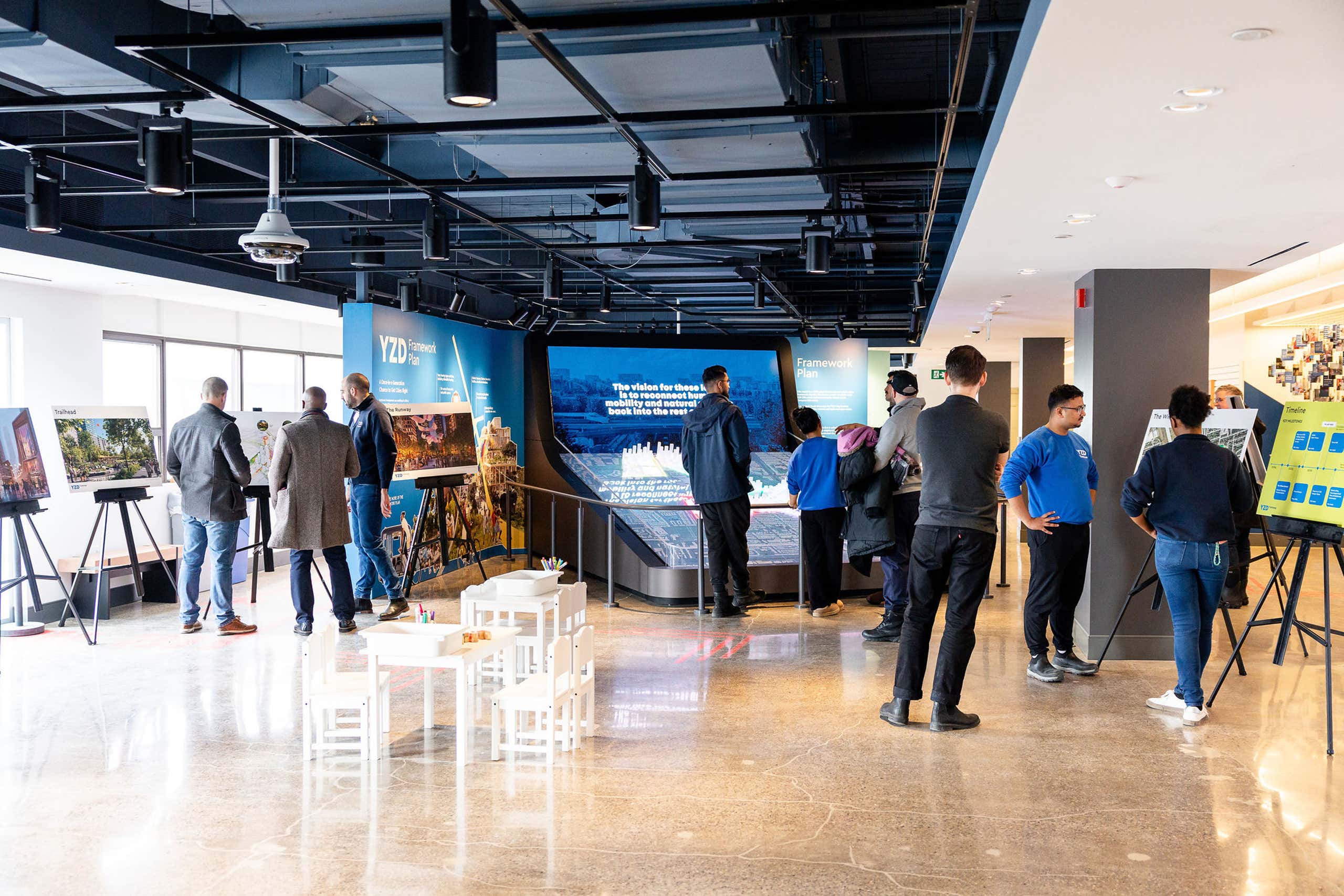 People exploring a YZD Framework Plan exhibition.
