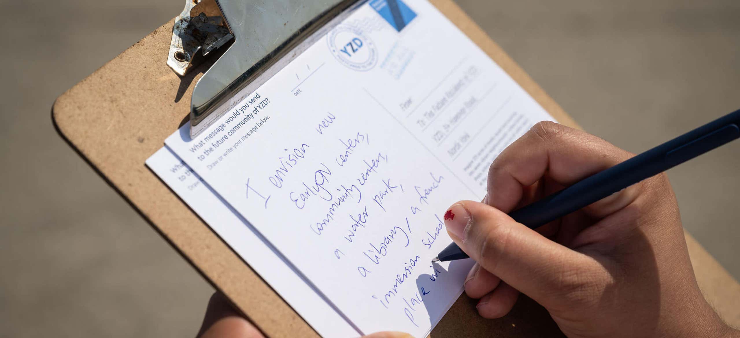 Person writing on a clipboard
